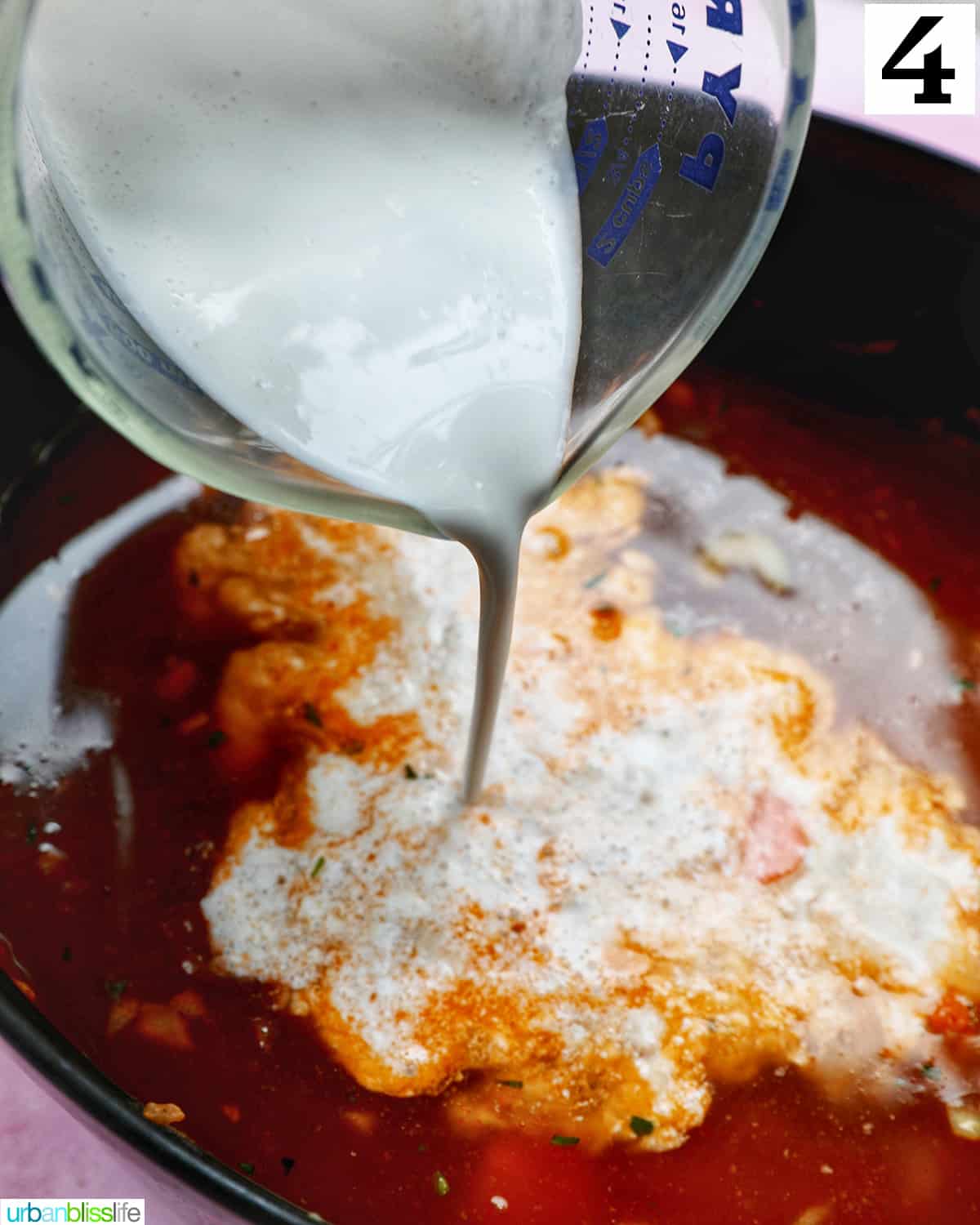 glass pitcher pouring heavy cream into bisque base.