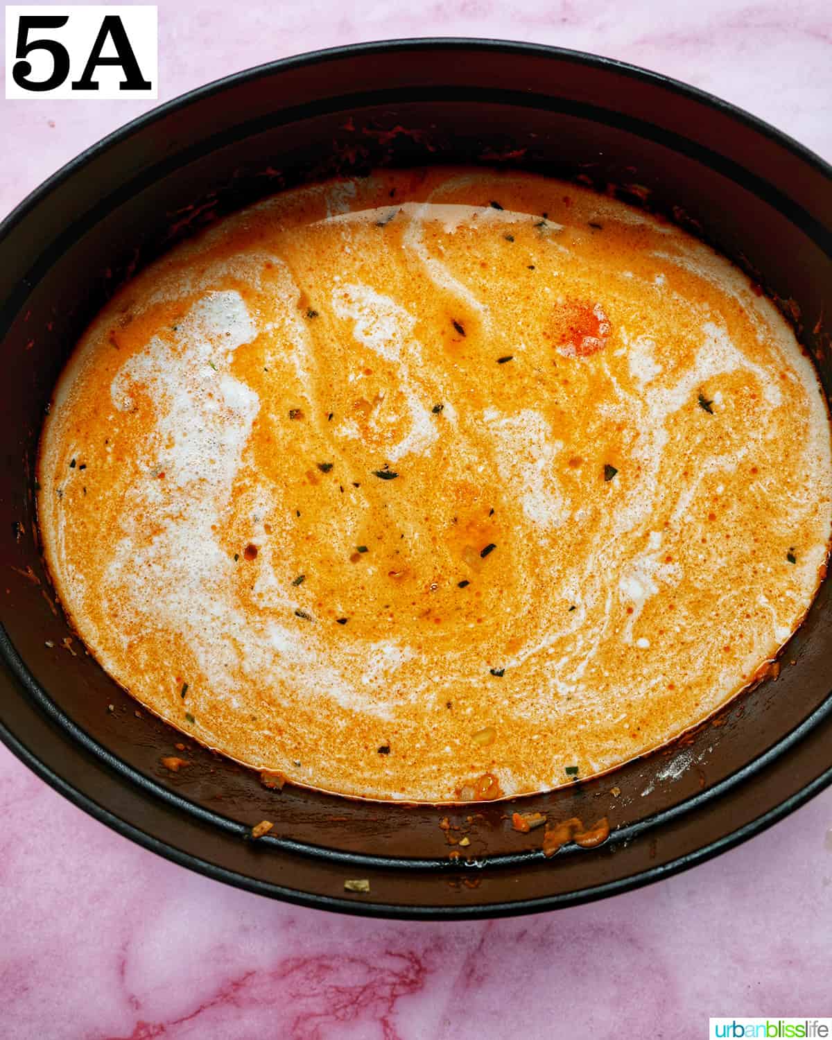 creamy tomato based shrimp and corn bisque in a dutch oven.