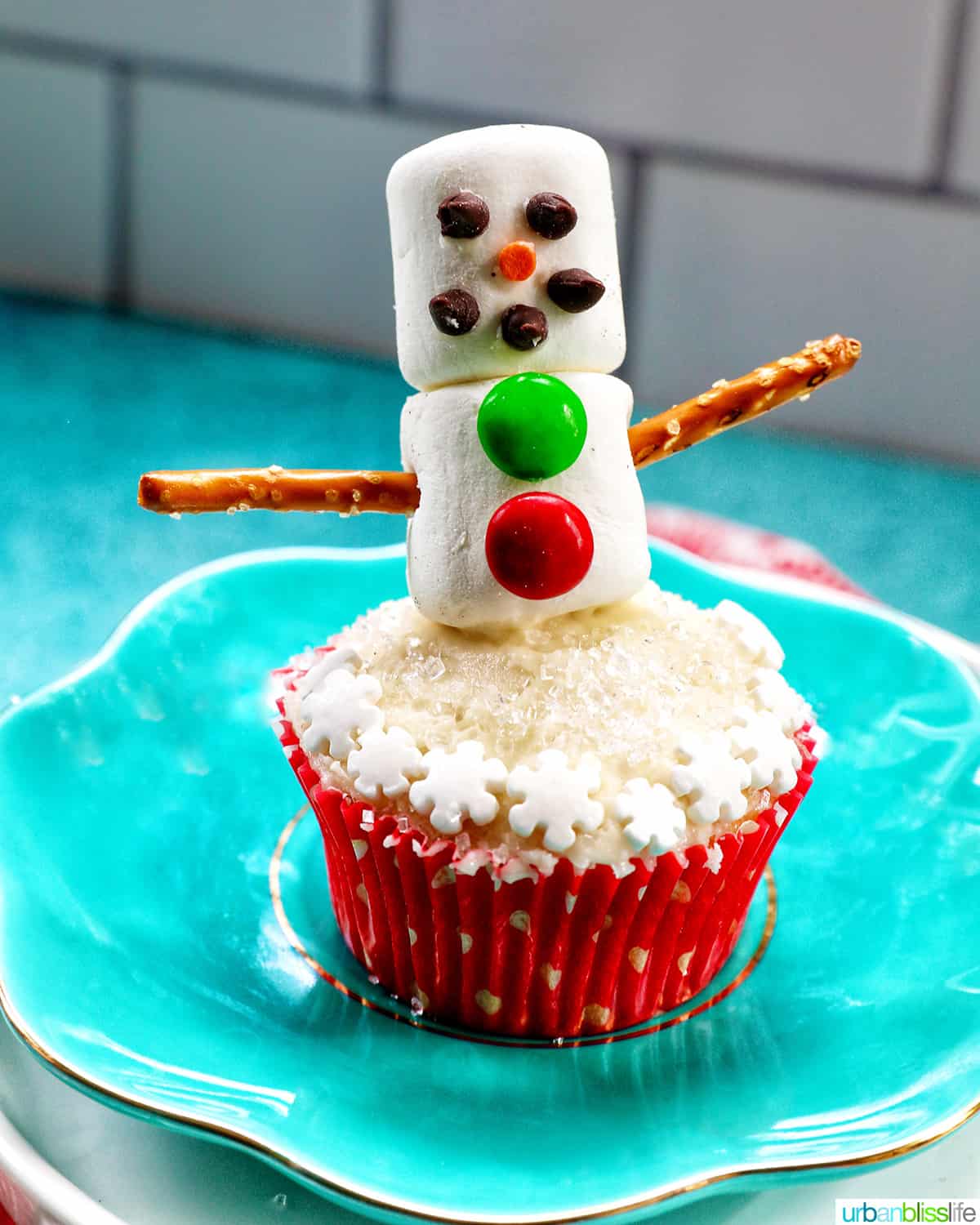 snowman cupcakes with marshmallows, pretzels, and sprinkles.