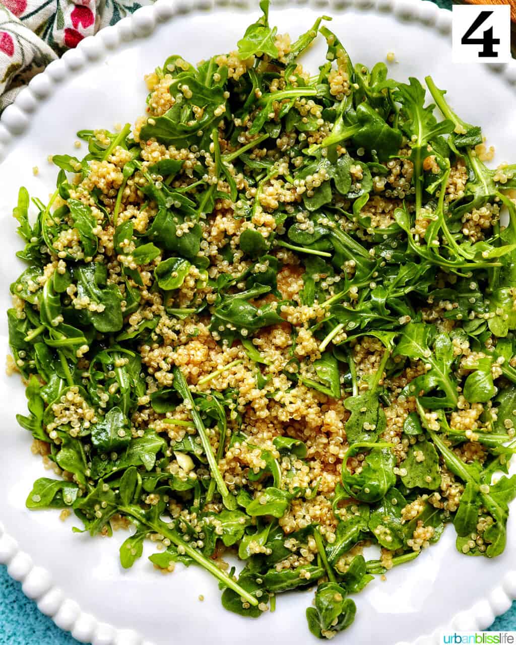 white bowl with arugula and quinoa salad.