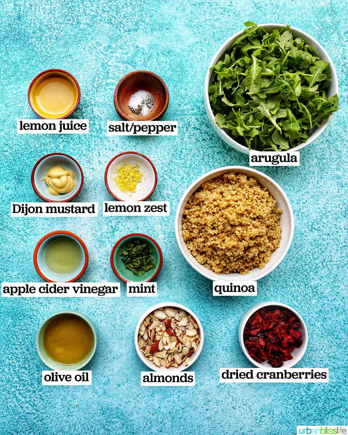 bowls of ingredients to make arugula and quinoa salad.