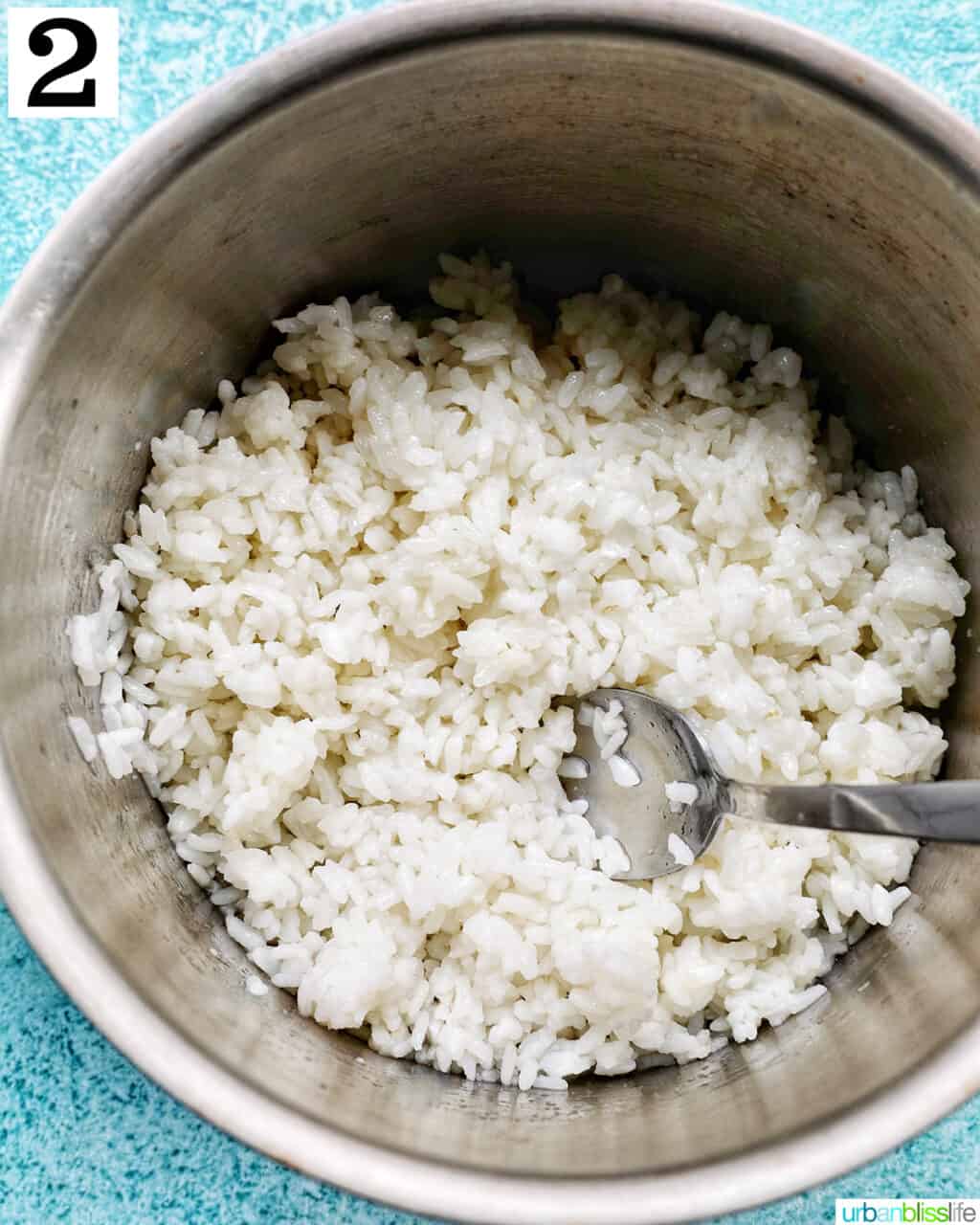 spoon with white rice in a pot.