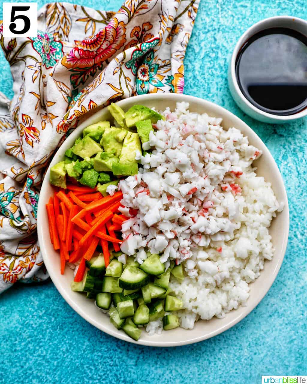 Carlifornia Sushi Bowls with crab, cucumbers, carrots, avocado, nori over white rice and a side of soy sauce.