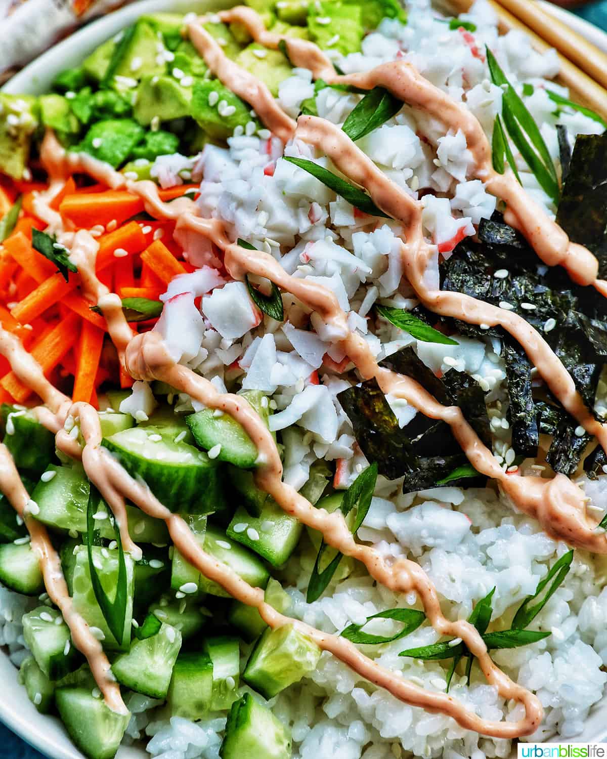 Carlifornia Sushi Bowls with crab, cucumbers, carrots, avocado, nori over white rice and drizzled with a sriracha mayo.