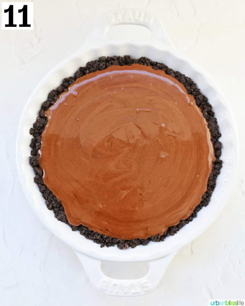 chocolate peppermint pie in oreo cookie crust in a white pie plate.