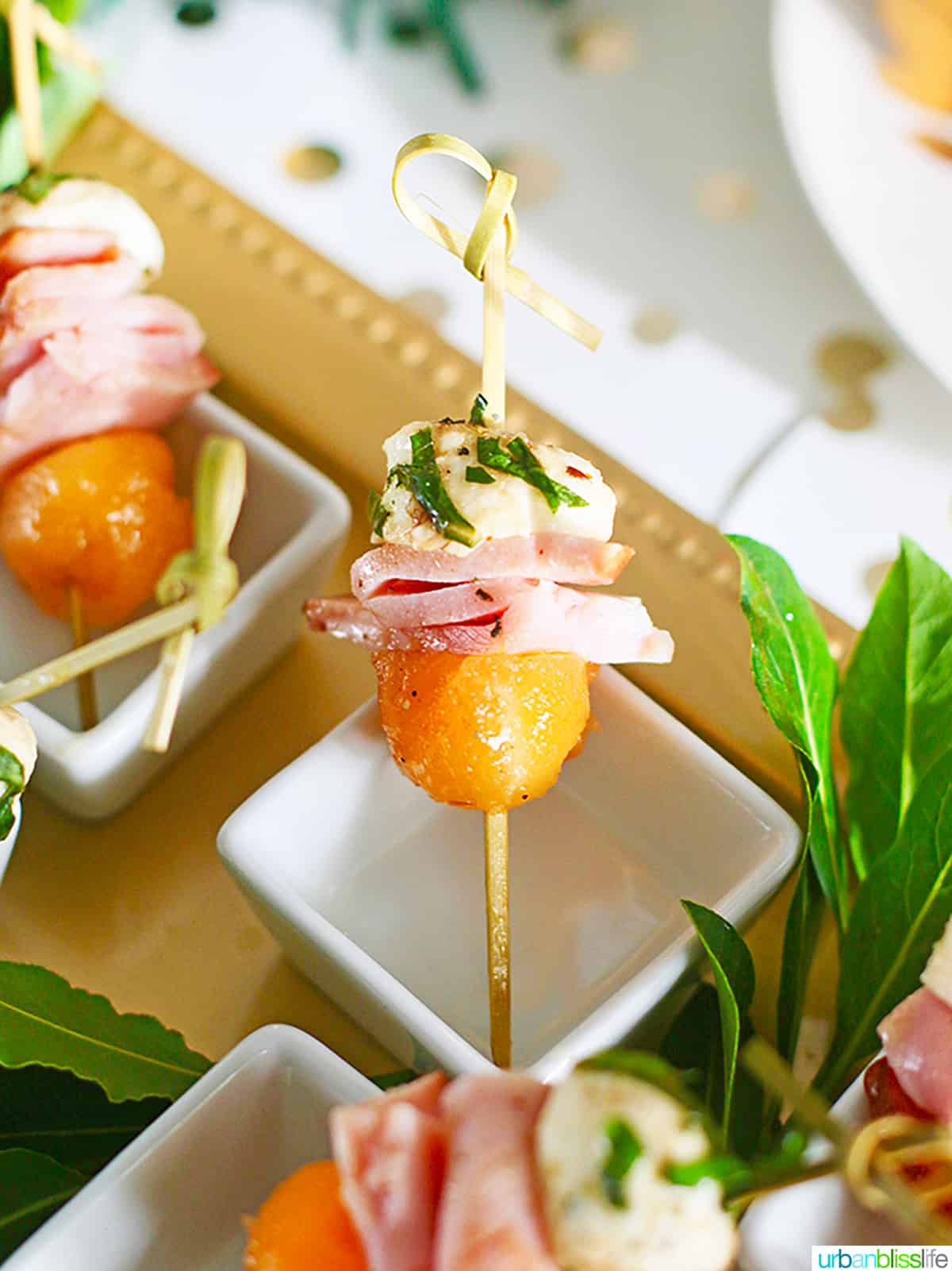ham, melon, and mozzarella bites on skewers.