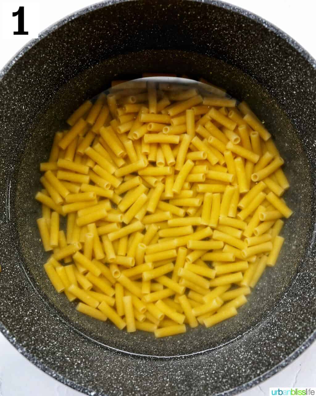 ziti pasta cooking in a large pot of water.
