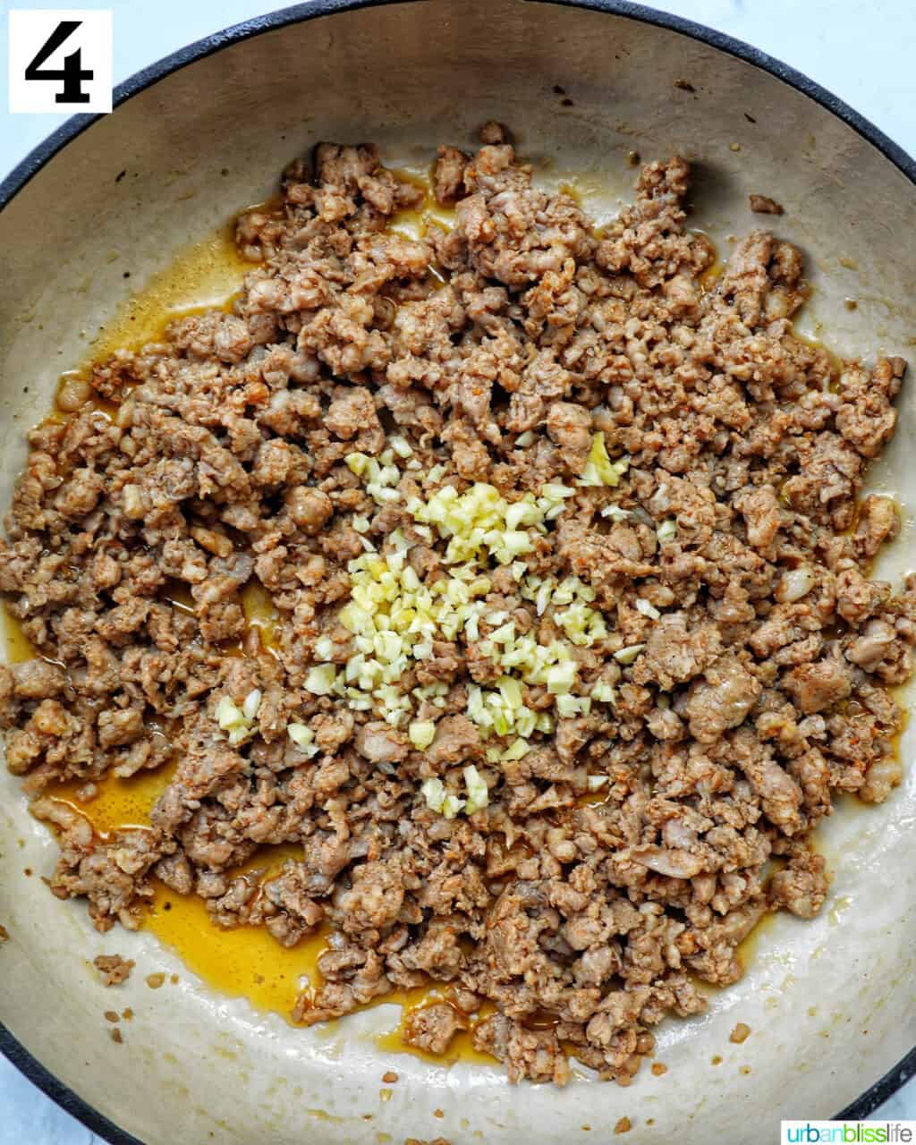 garlic and Italian sausage cooking in a large skillet.
