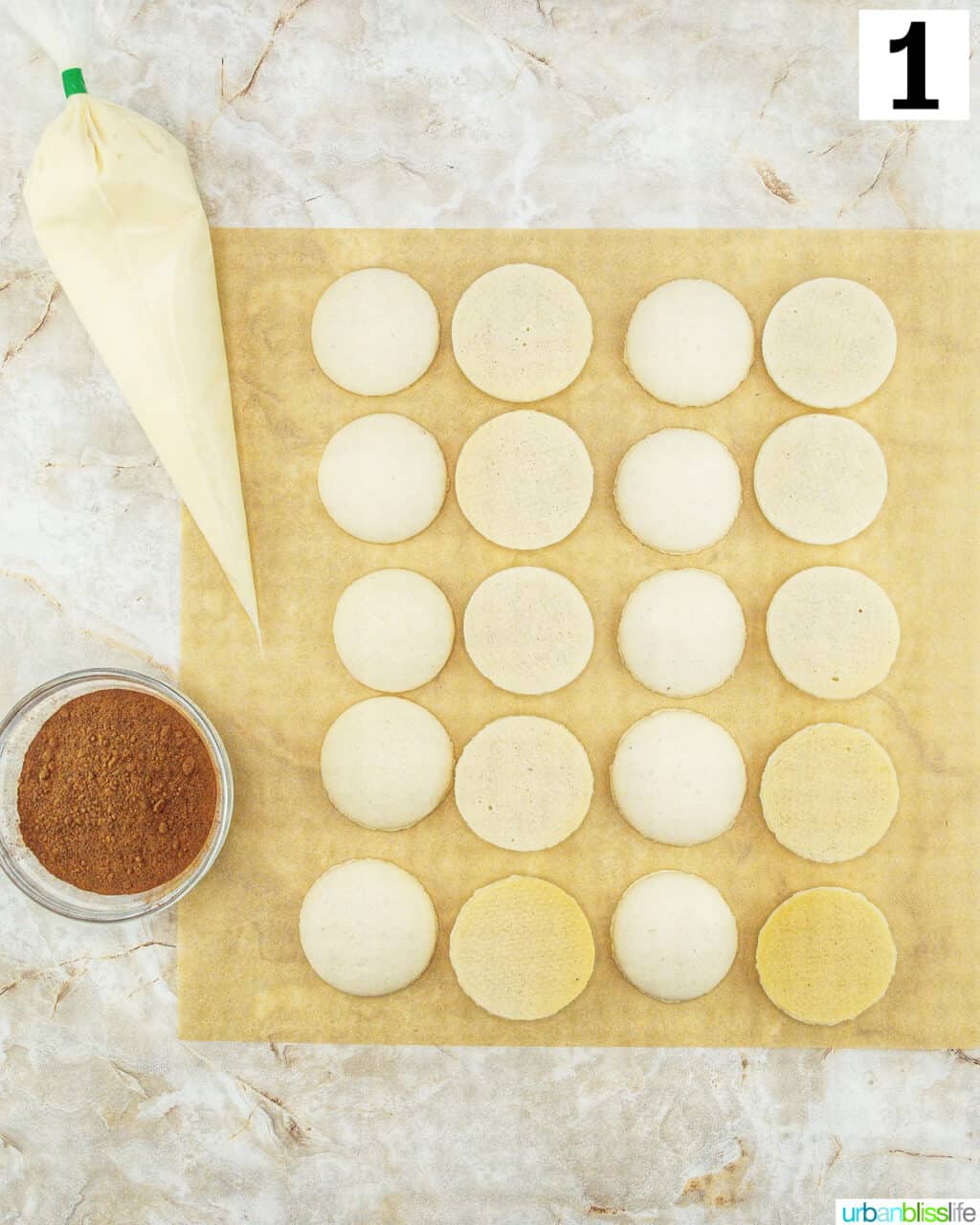 piping bag next to piped macaron cookie shells.