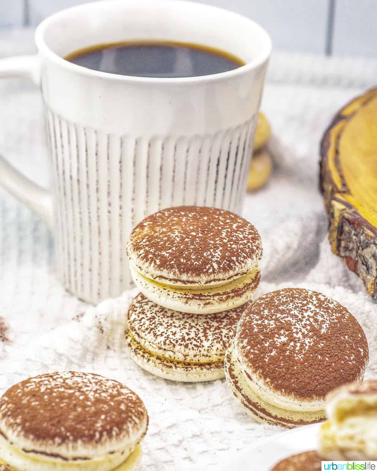 stacks of tiramisu macarons with a cup of coffee.