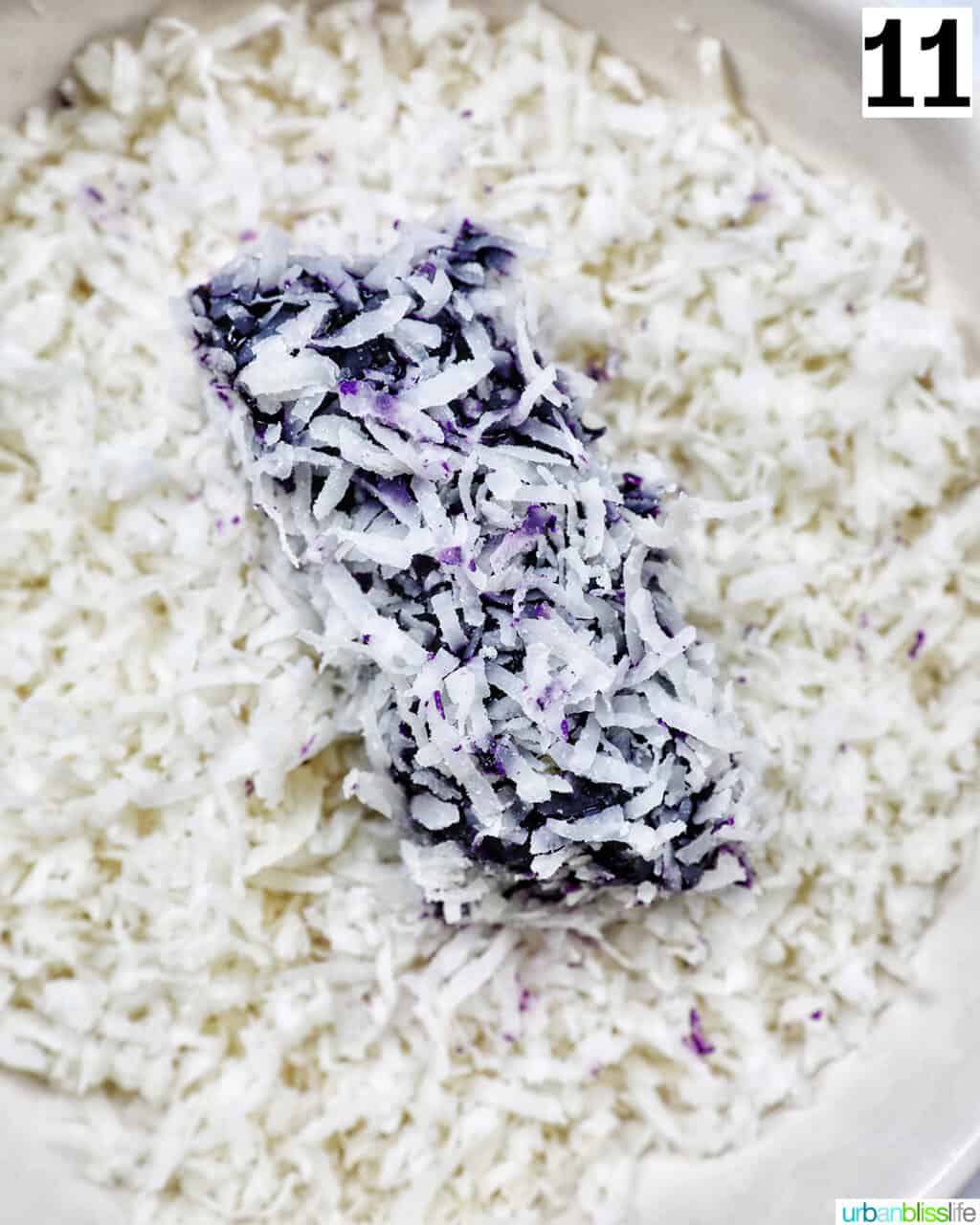 rolling a purple ube bar in shredded coconut.