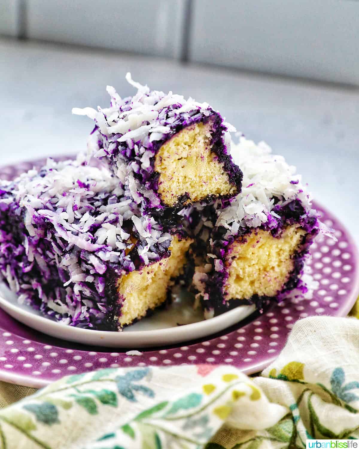 three sliced ube bars on a purple plate.