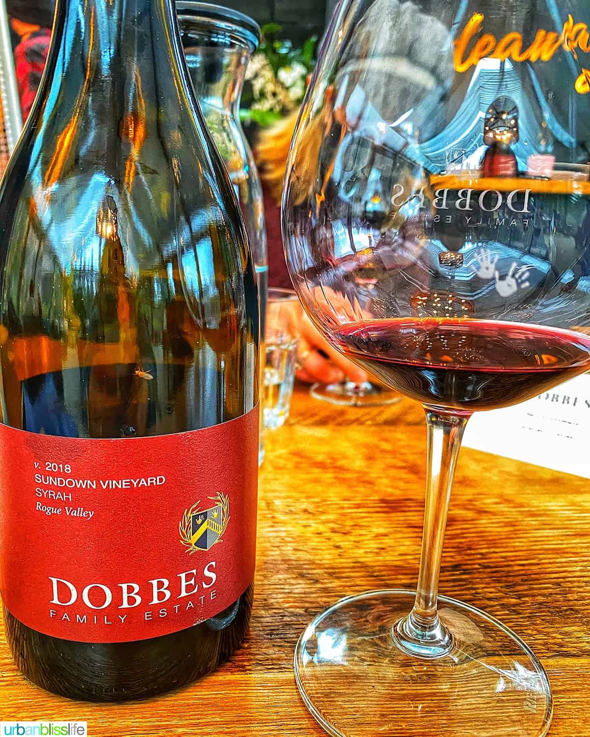 bottle of Dobbes winery Syrah red wine with glass of red wine.