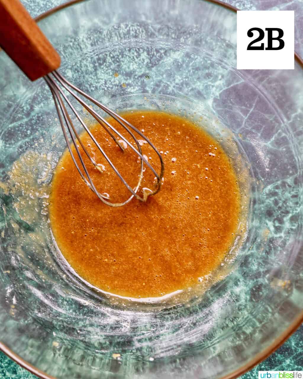 whisk in bowl with whisked glaze.