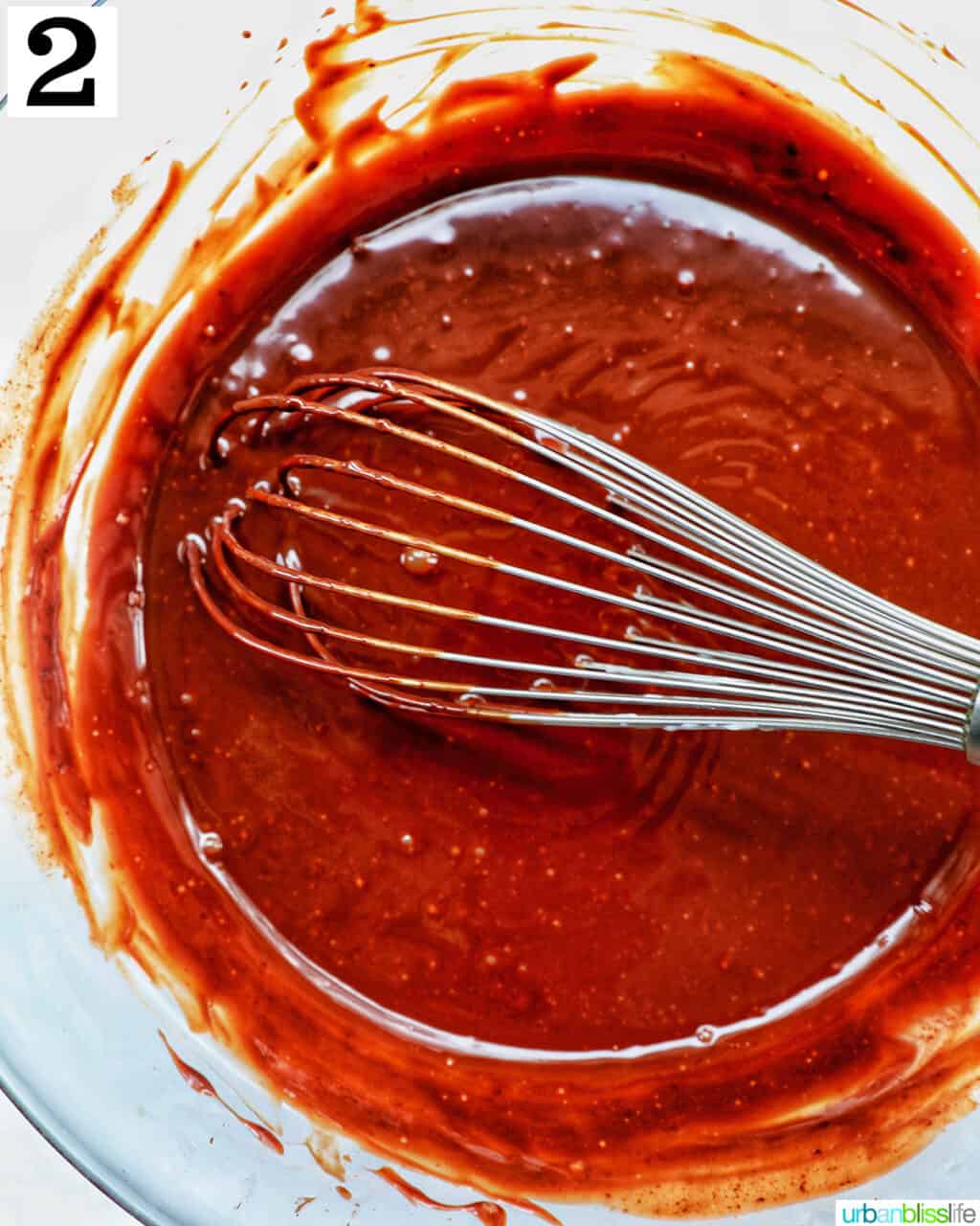 whisk with chocolate ganache in a bowl.