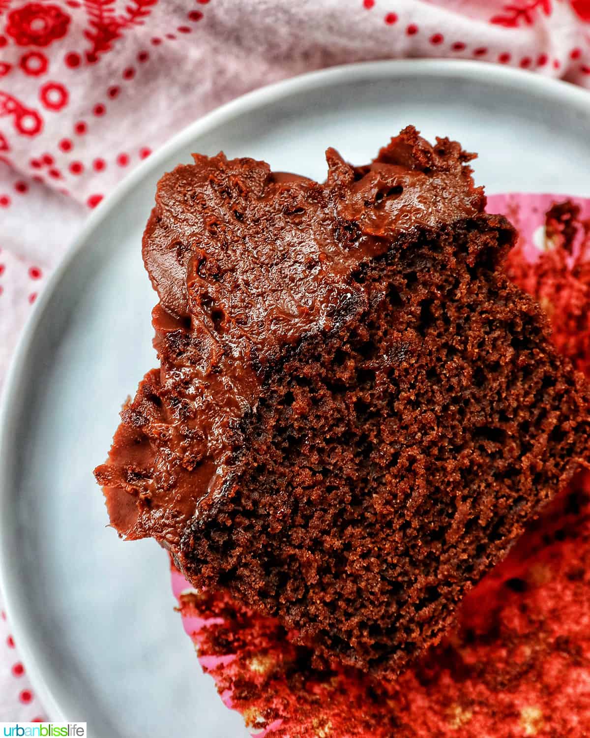 one chocolate fudge cupcake topped with chocolate ganache frosting cut in half.