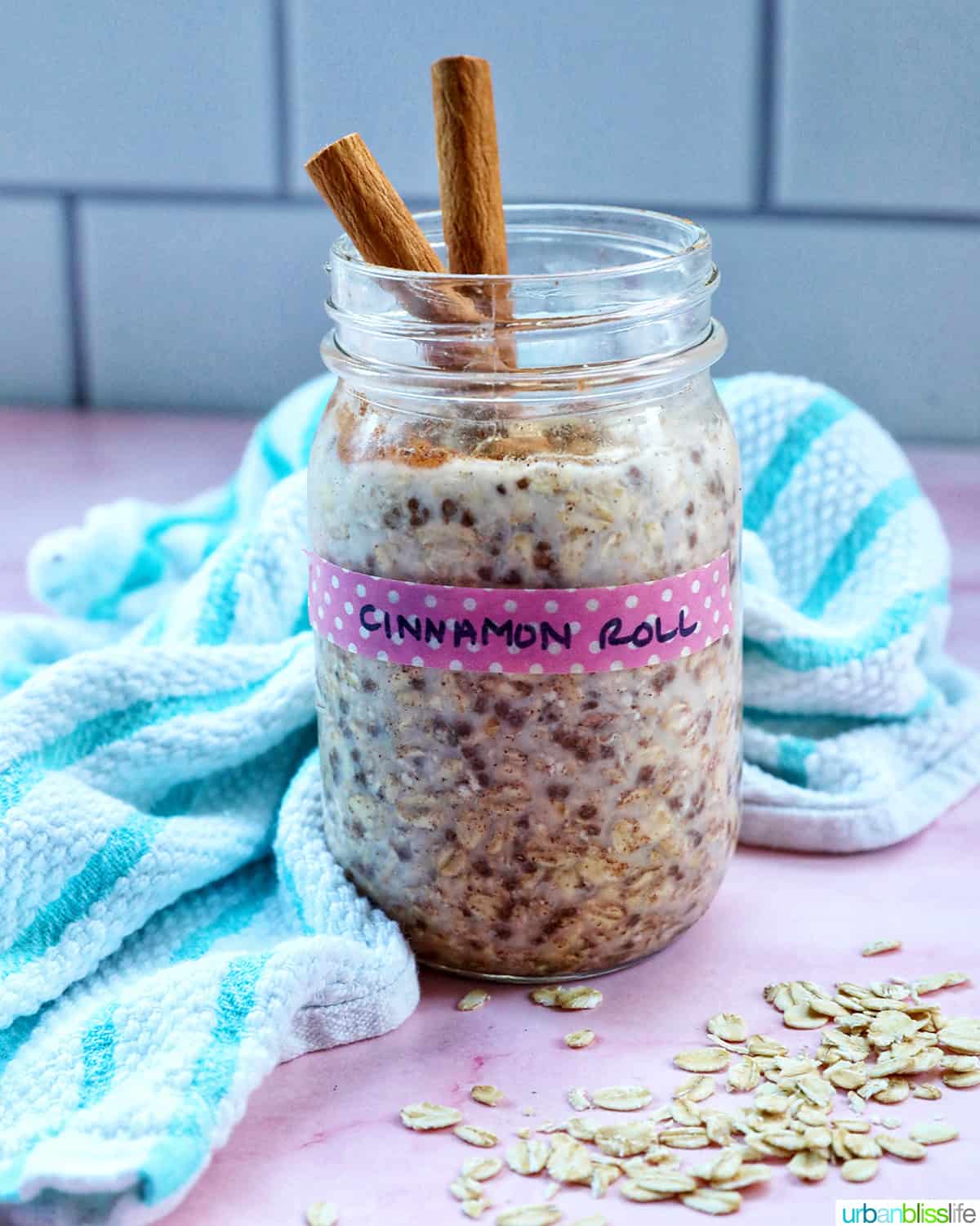 cinnamon roll overnight oats in a mason jar with cinnamon sticks on top..