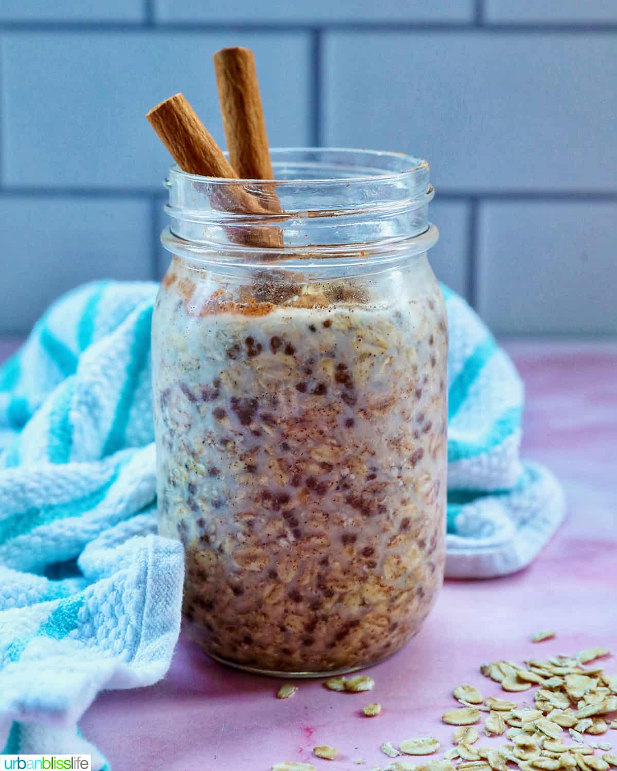 cinnamon roll overnight oats in a mason jar with cinnamon sticks on top..