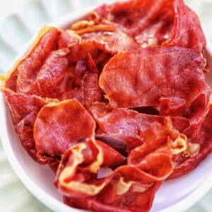 crispy prosciutto in a small white bowl.