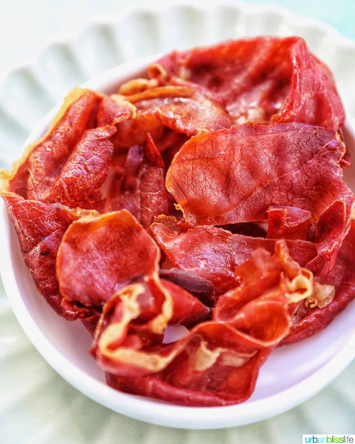 crispy prosciutto in a small white bowl.