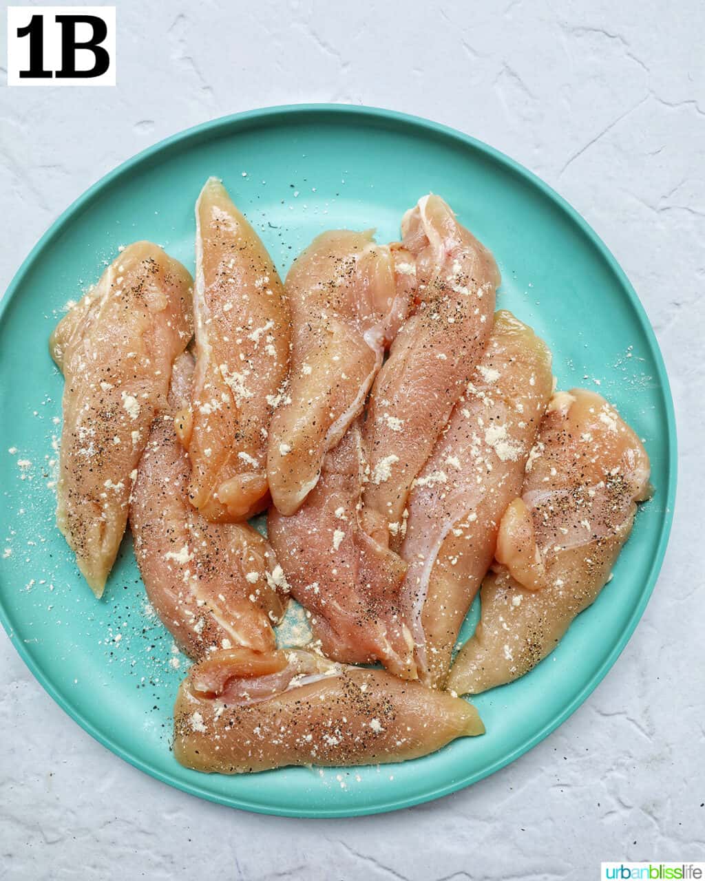 plate of seasoned raw chicken tenders.