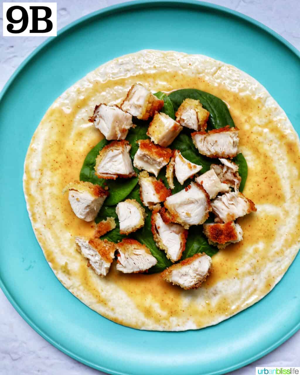 chicken tenders on top of spinach and a tortilla wrap.