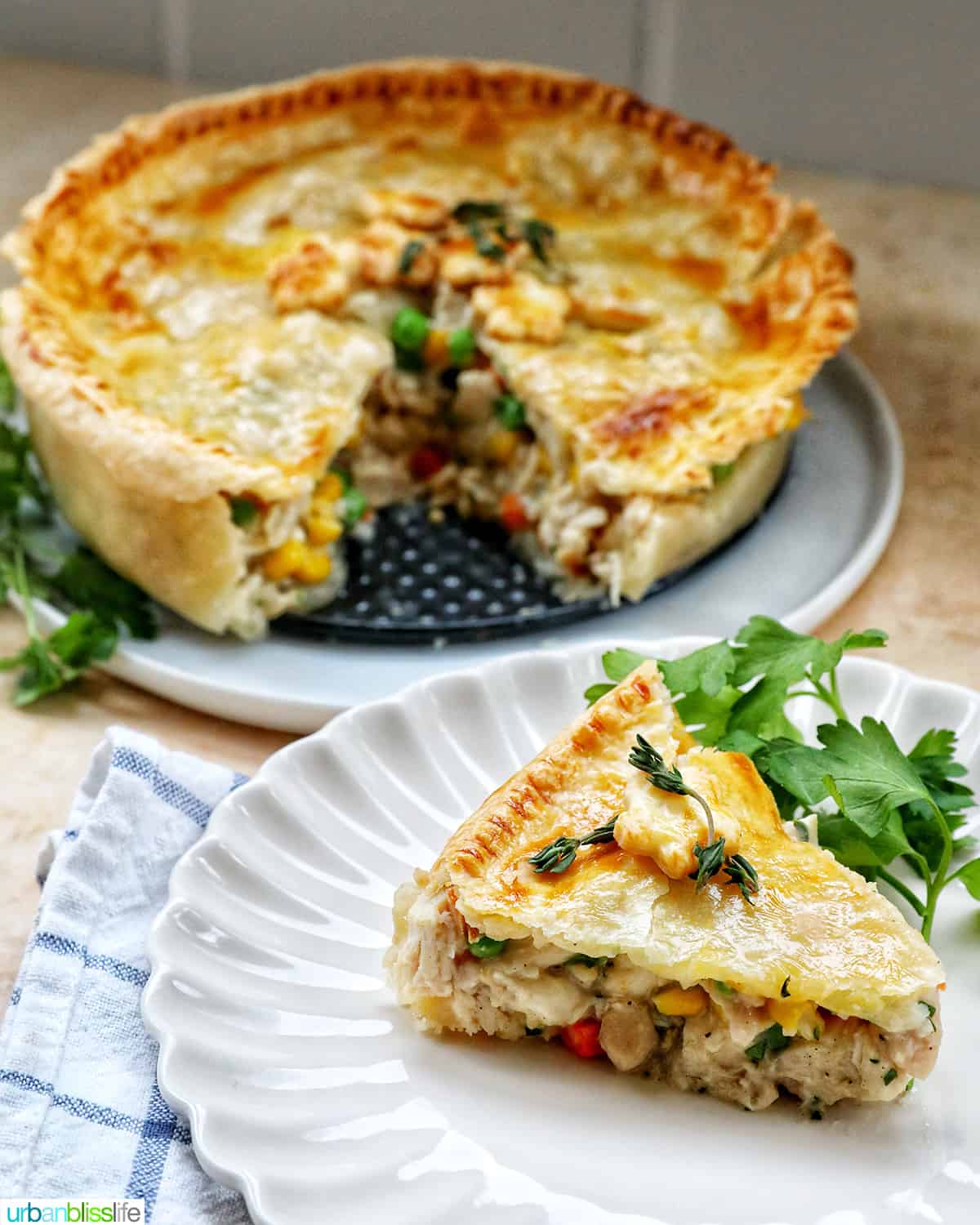 slice of air fryer chicken pot pie on a plate with a full chicken pot pie behind it.