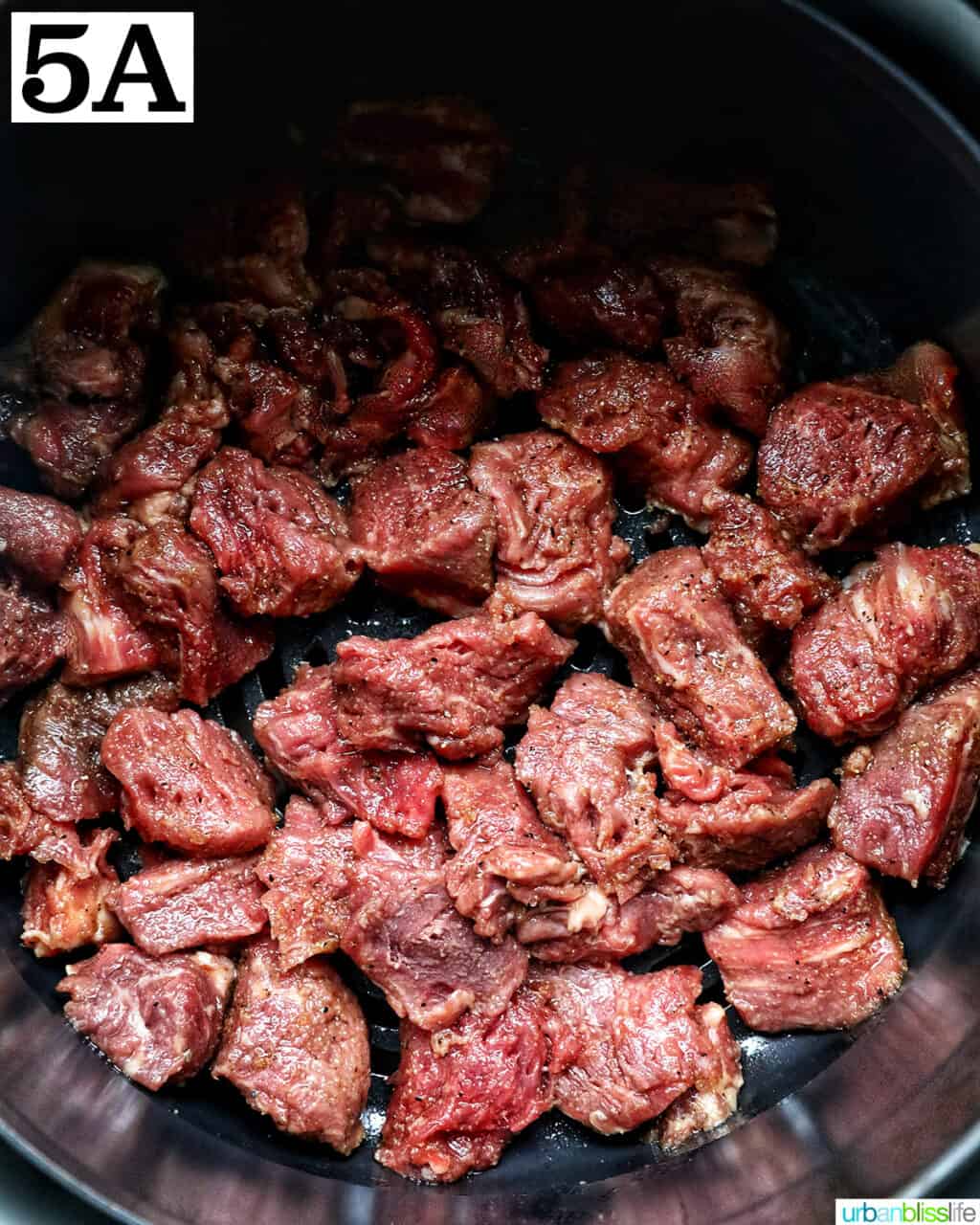 air fryer steak bites in an air fryer basket.