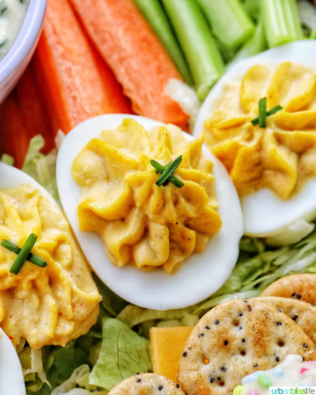 deviled eggs in front of sliced carrots and celery.