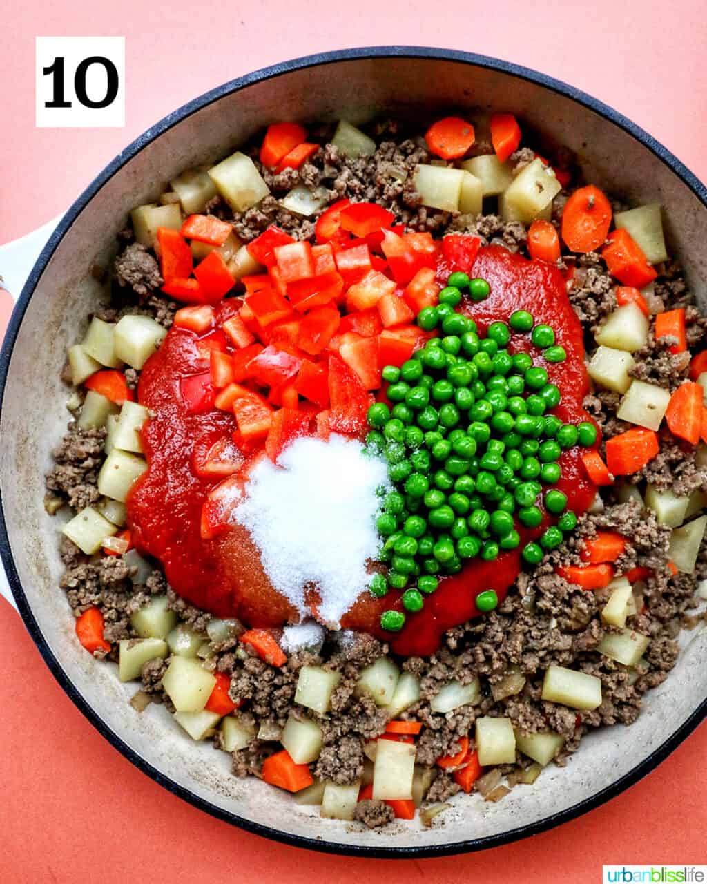 sugar and peas added to a large pan of Filipino beef giniling cooking.