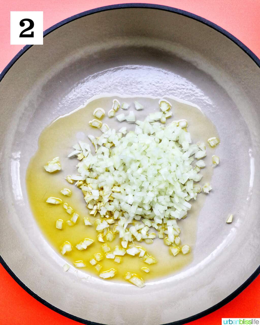 chopped onions and garlic on olive oil in a large white pan.