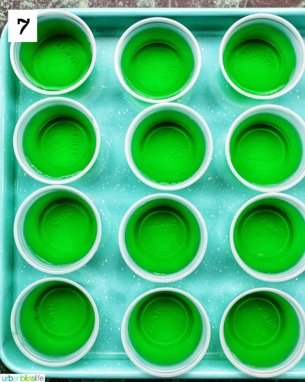 set of green jello shots on a blue pan.