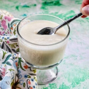 spoon dipped into a parfait bowl with homemade vanilla pudding.