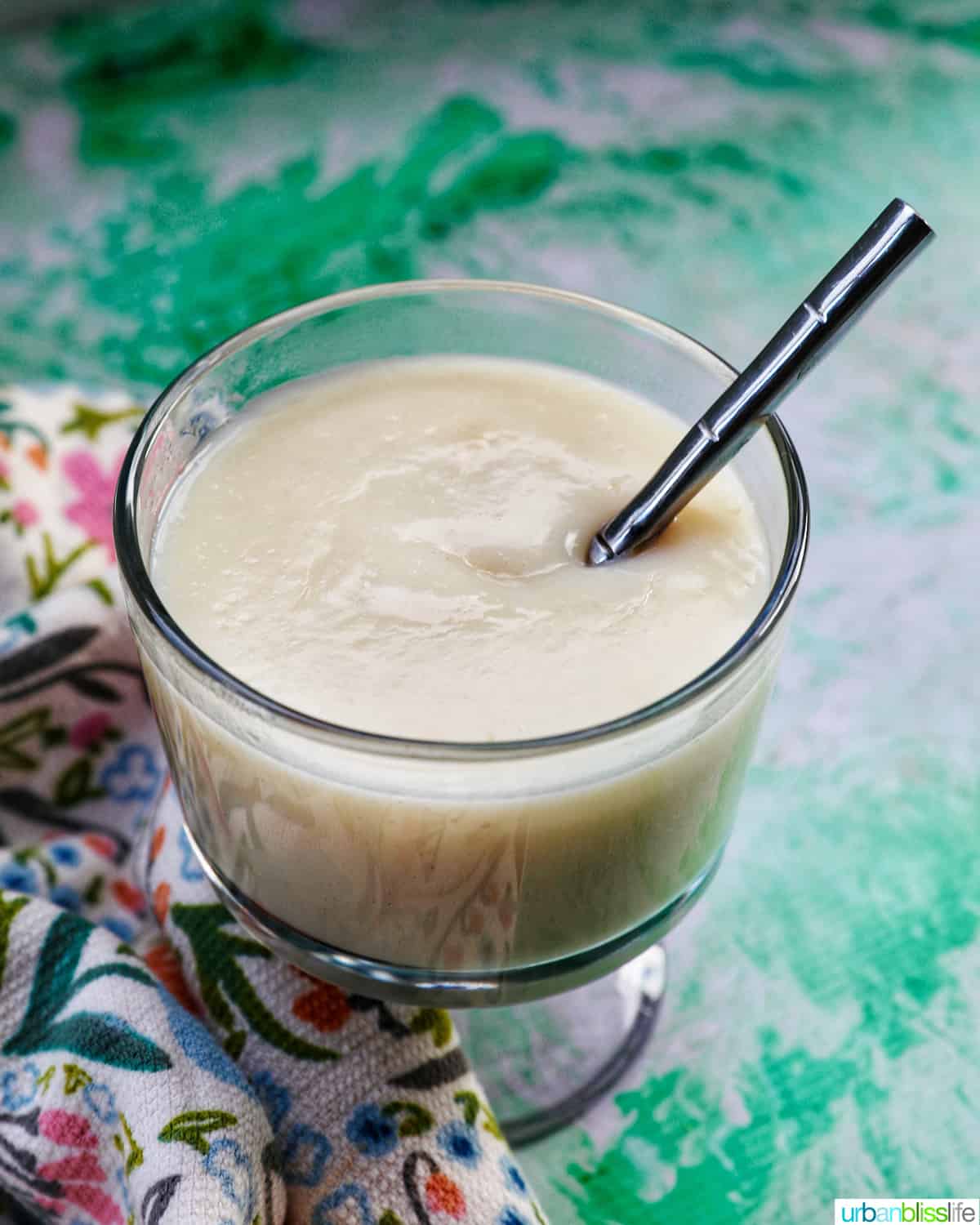 spoon dipped into a parfait bowl with homemade vanilla pudding.