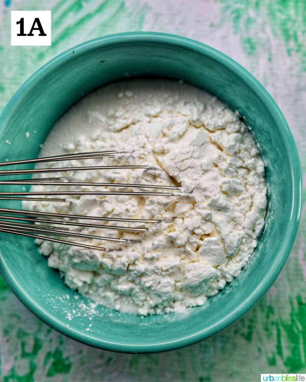 bowl with a whisk and powdered ingredients.