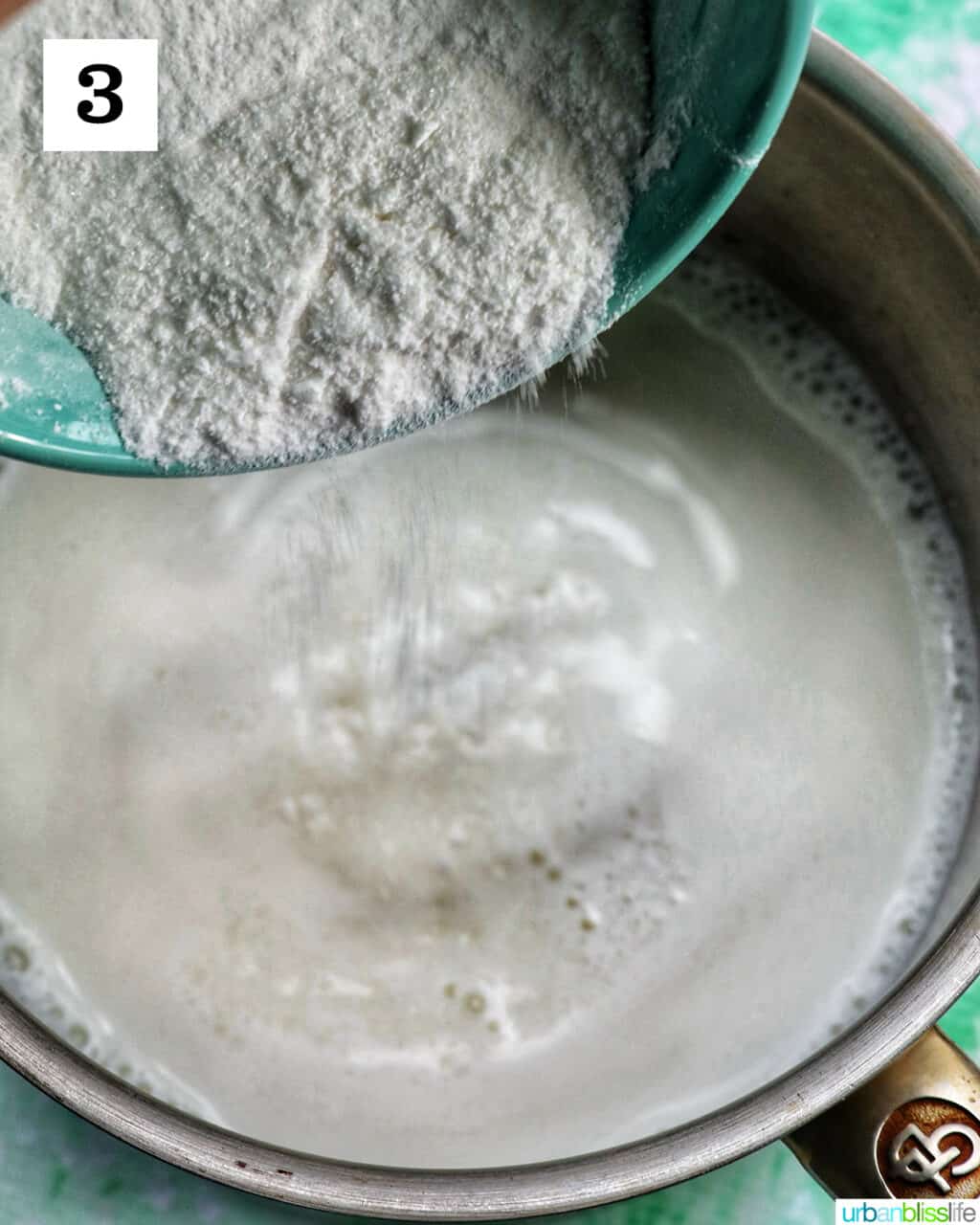 white powdered ingredients being added to liquid ingredients in a saucepan.