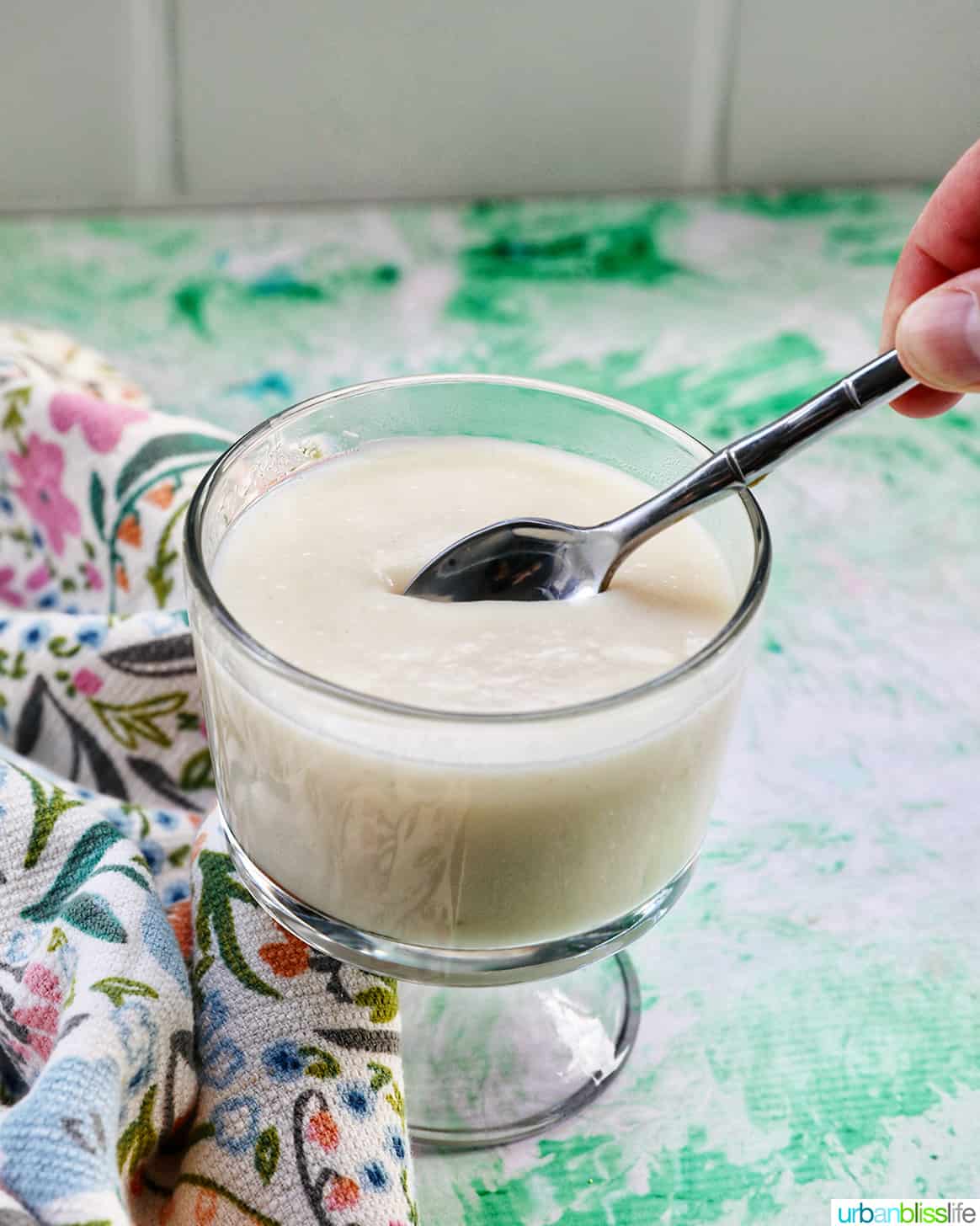 spoon dipped into a parfait bowl with homemade vanilla pudding.