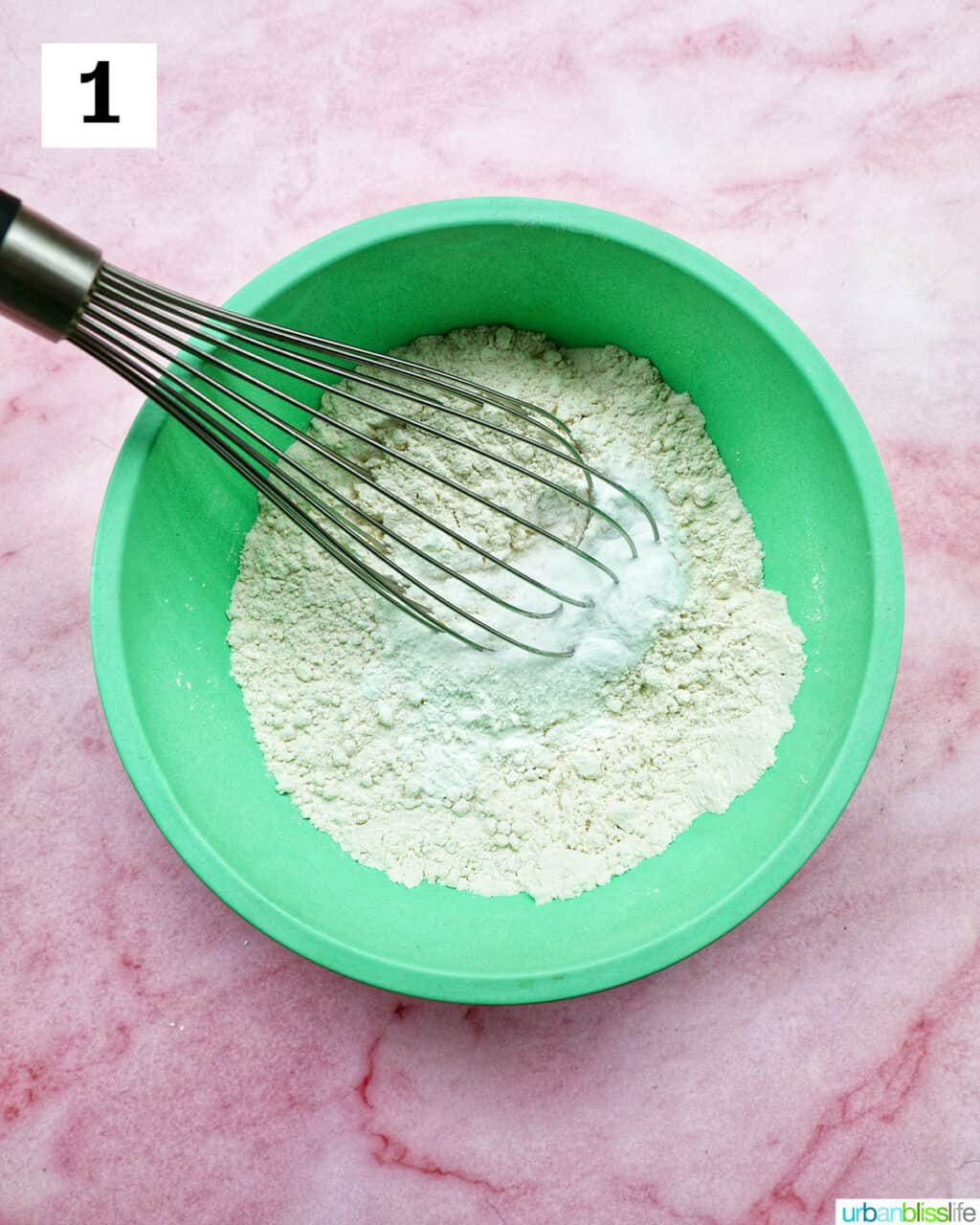 whisk and dry ingredients in a green bowl.