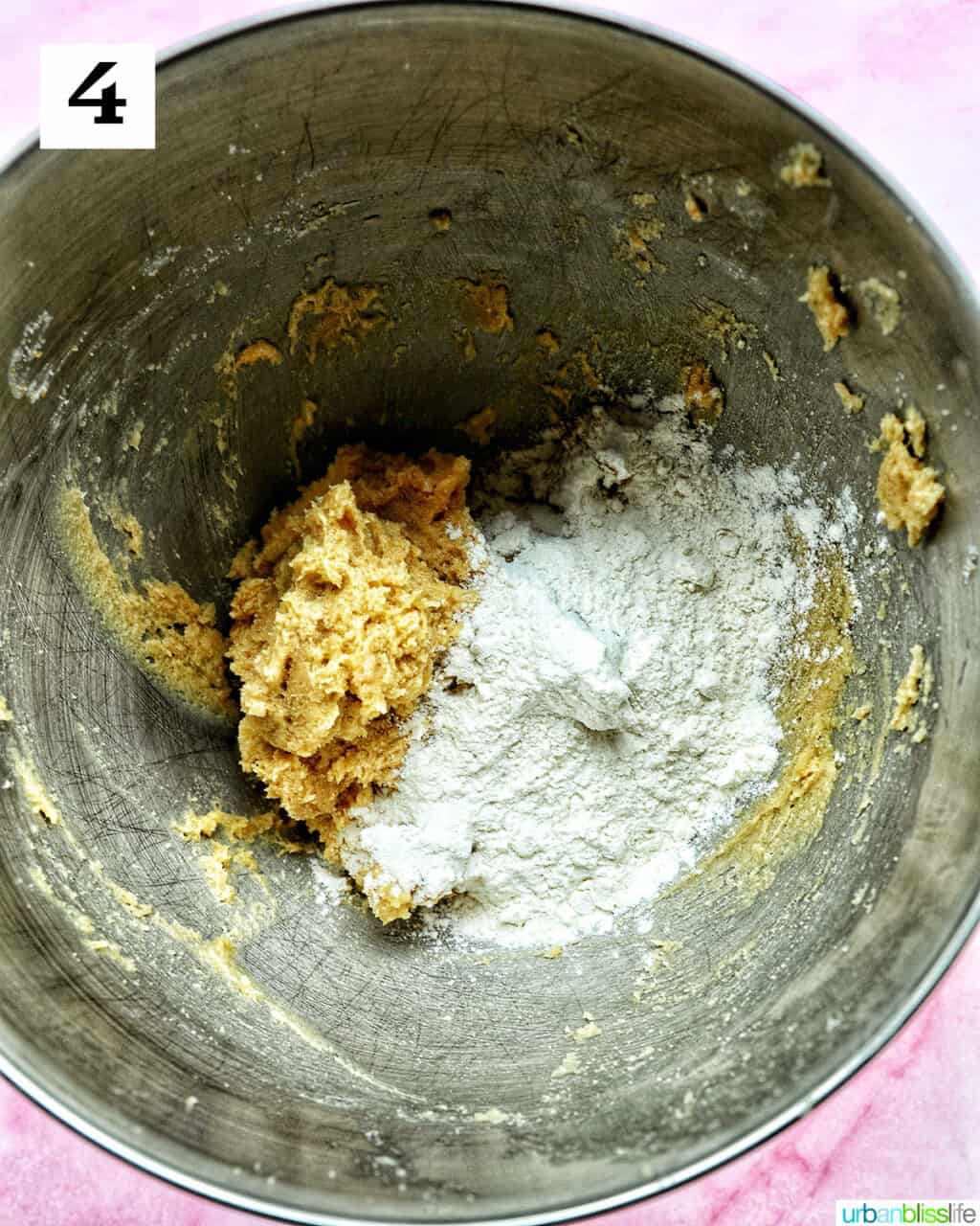 cookie batter with flour mixture added in a stand mixer bowl.
