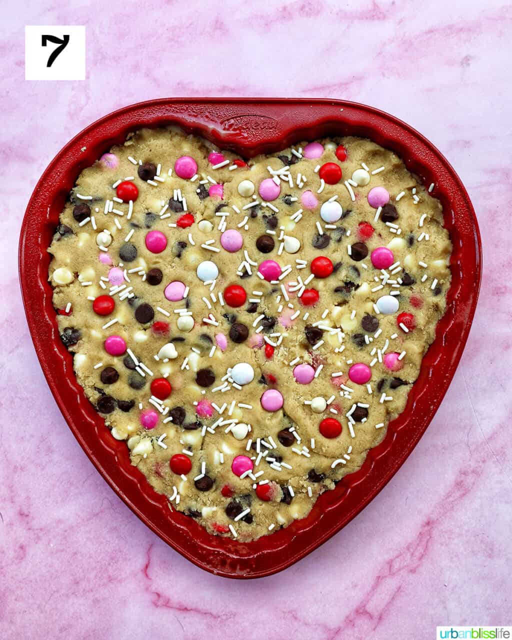 A heart-shaped Valentine's Day cookie cake with red, white, and pink M & M decorations.
