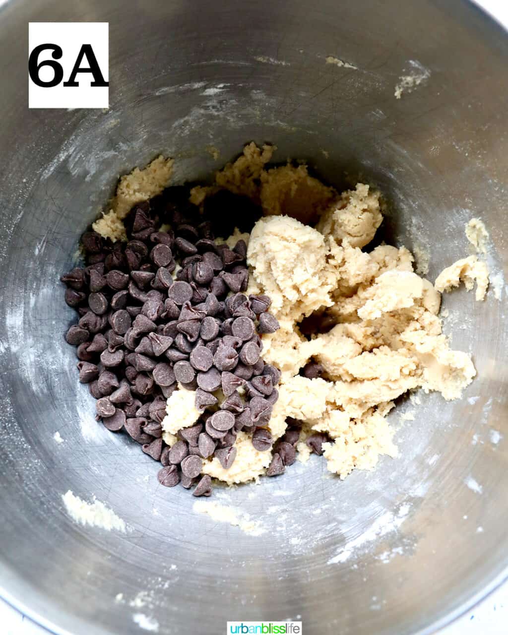 chocolate chips added to cookie dough in a stand mixer bowl.