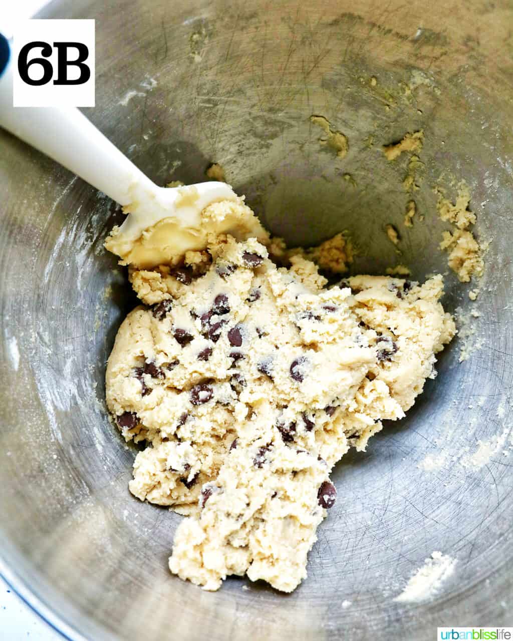 chocolate chip cookie dough and a spatula in a stand mixer bowl.