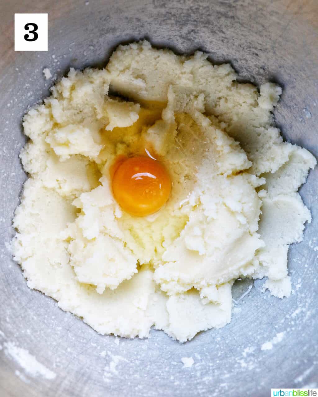 raw egg over a mixture of butter and sugar in a bowl.