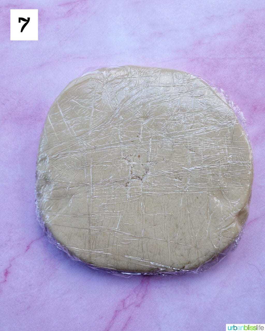 cookie dough shaped into a round disc and wrapped with plastic wrap.