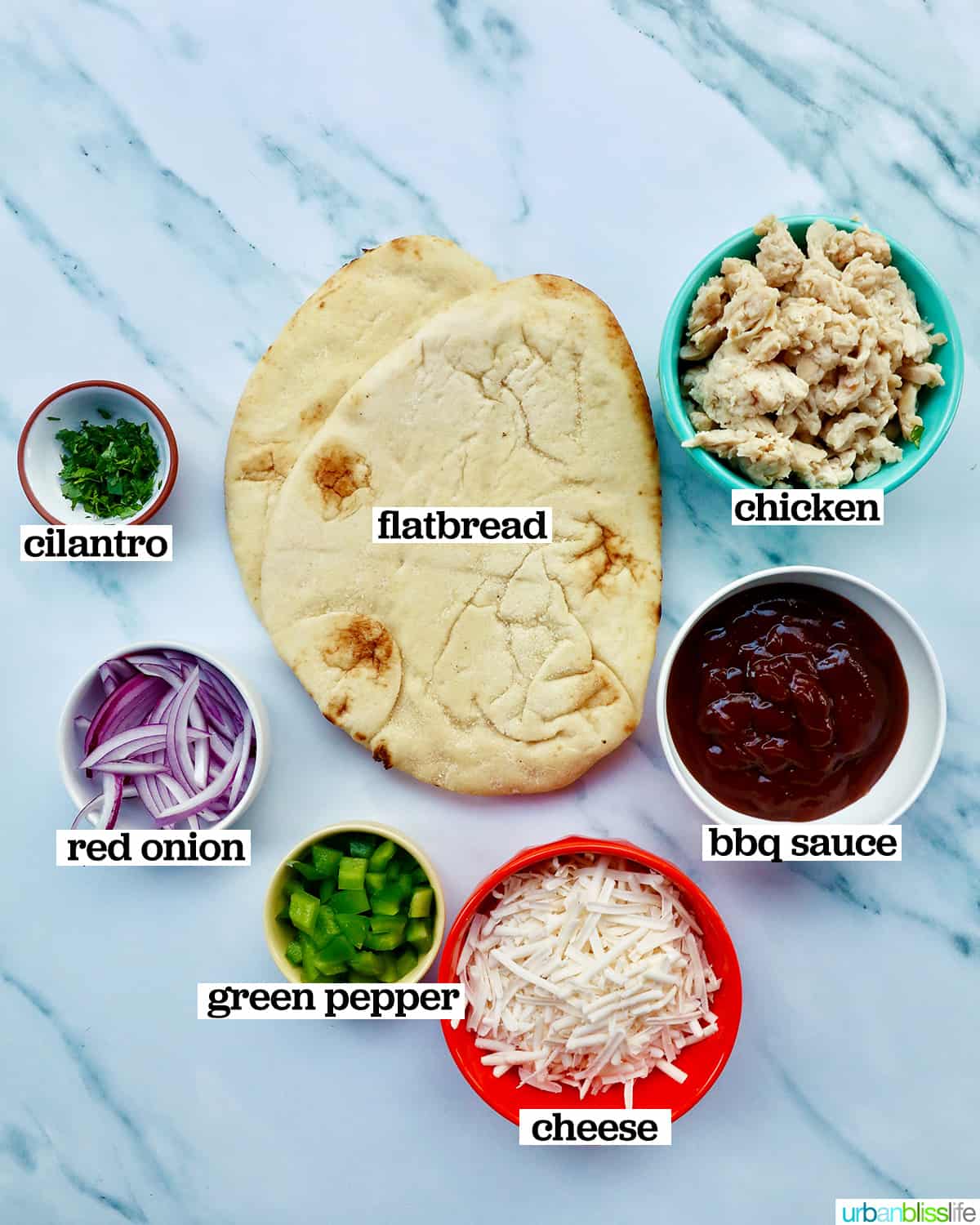 ingredients to make bbq chicken flatbread pizza on marble.