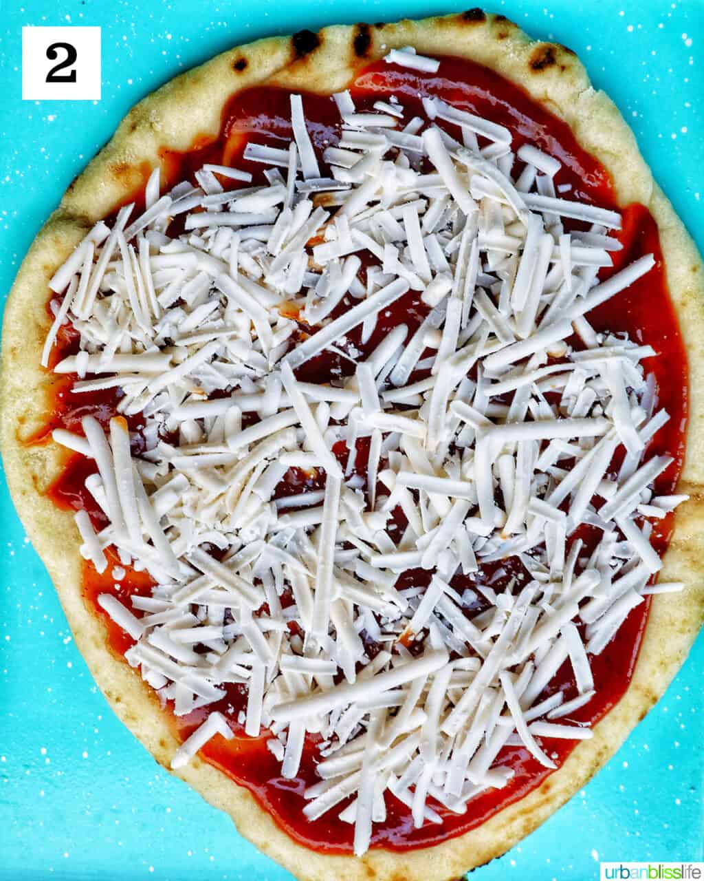 shredded cheese over barbecue sauce on flatbread.