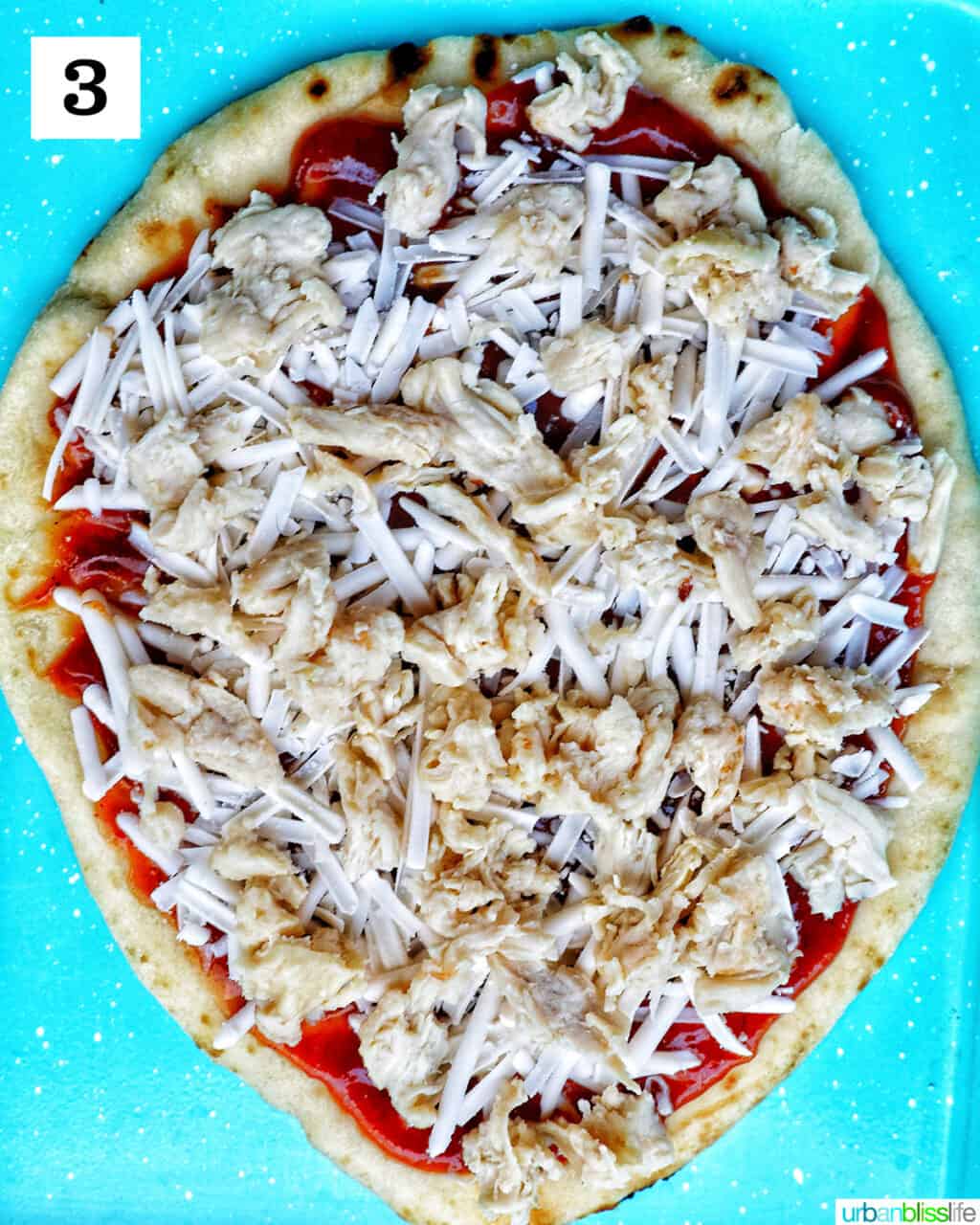 chicken breast and shredded cheese over barbecue sauce on flatbread.