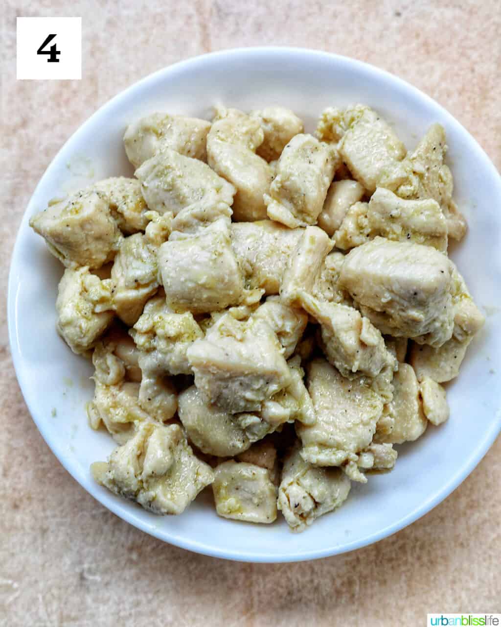 cooked chicken cubes in a white bowl.