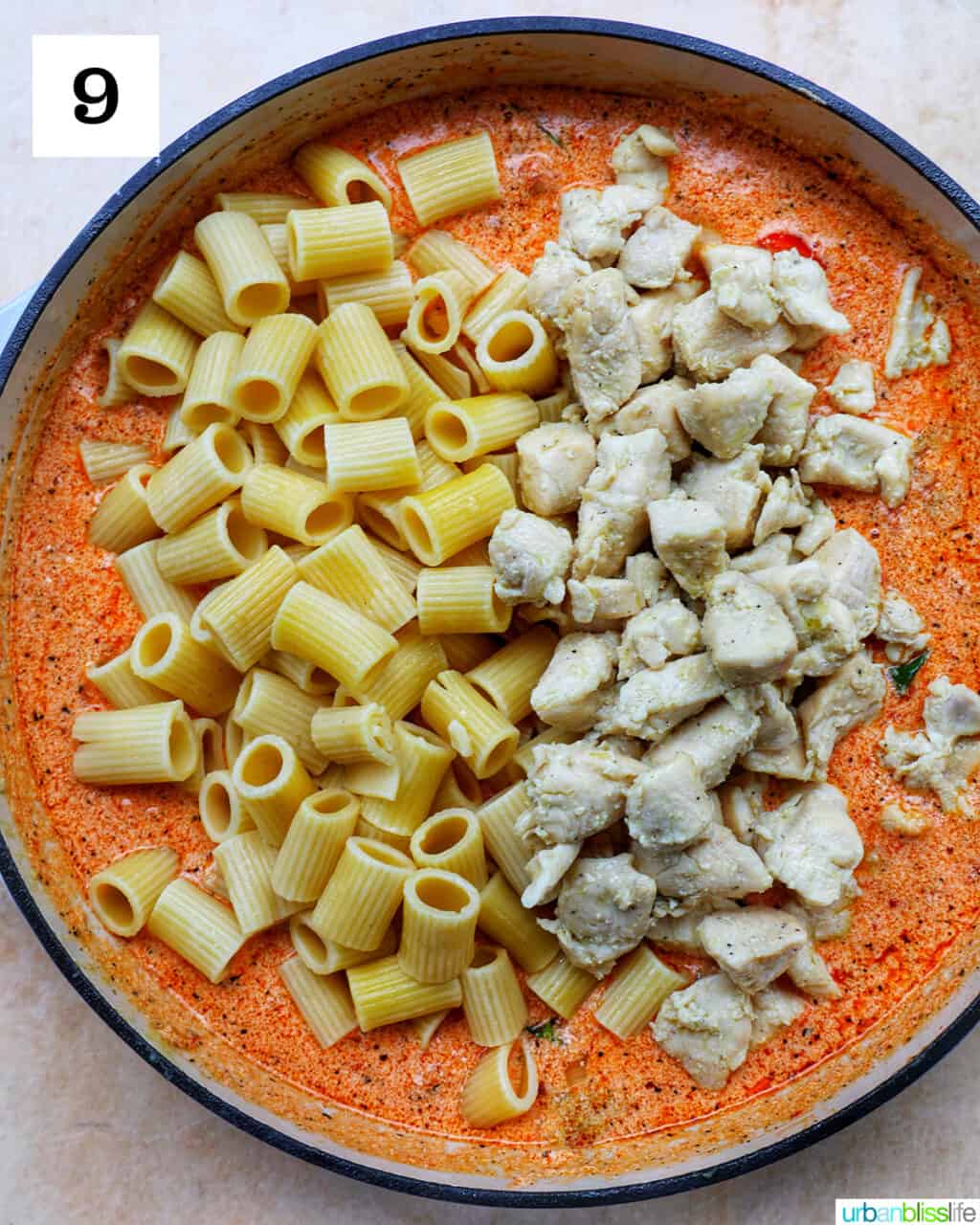 rigatoni pasta and cooked chicken with sun-dried tomato cream sauce in a large skillet.