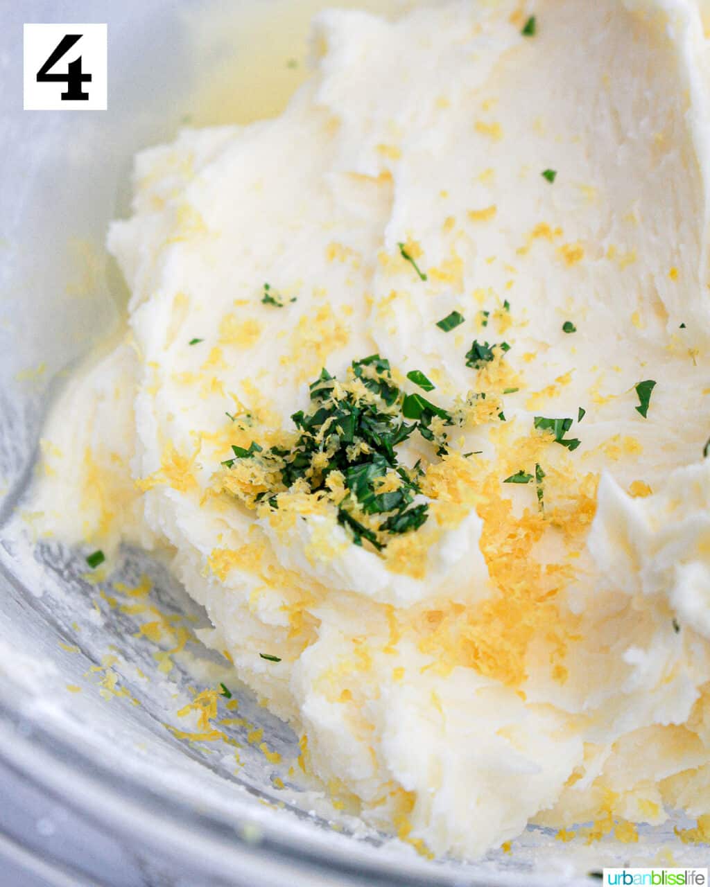 chopped fresh basil and lemon zest added to buttercream frosting in a large bowl.